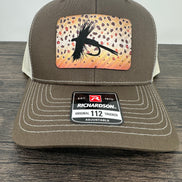 A brown and beige fly fishing hat with a laser engraved fly on a brown trout printed patch