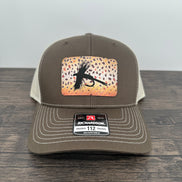 A brown and beige fly fishing hat with a laser engraved fly on a brown trout printed patch