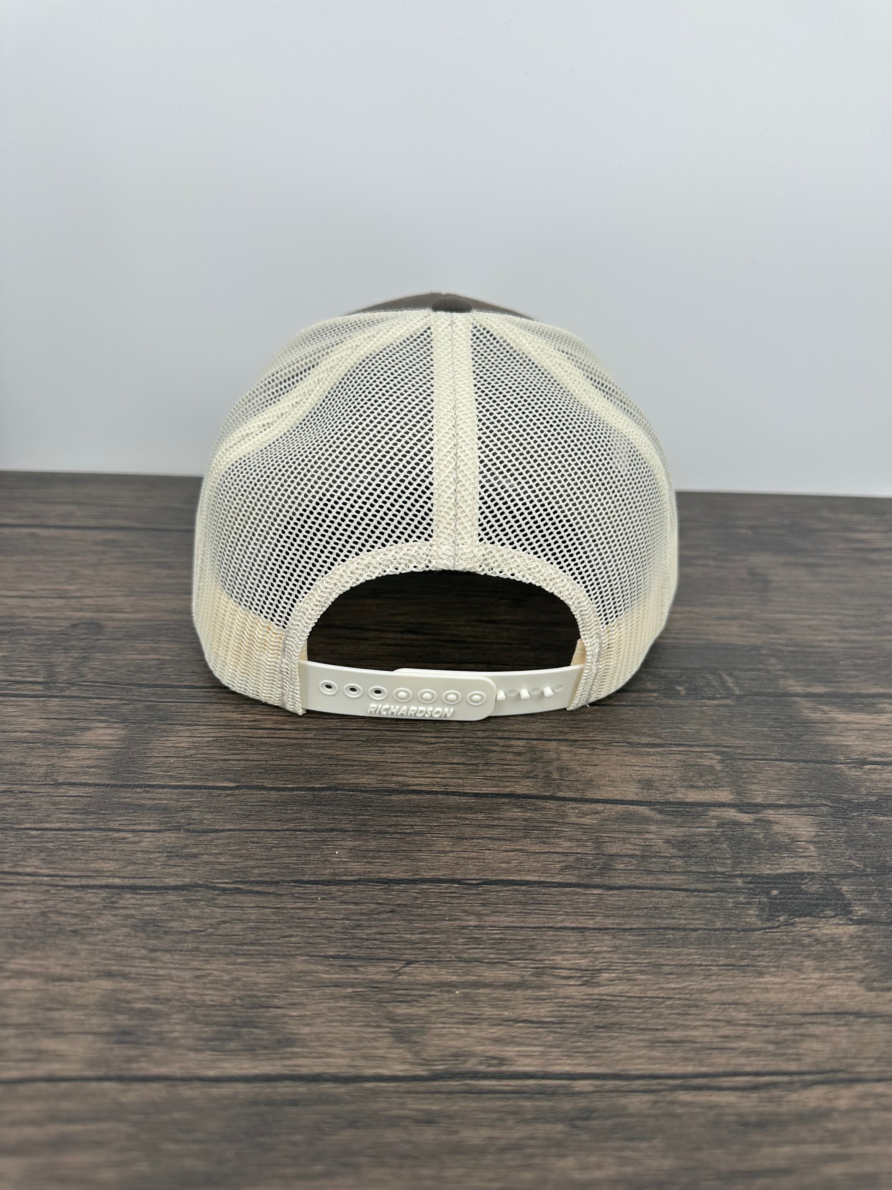 Back view A brown and beige fly fishing hat with a laser engraved fly on a brown trout printed patch