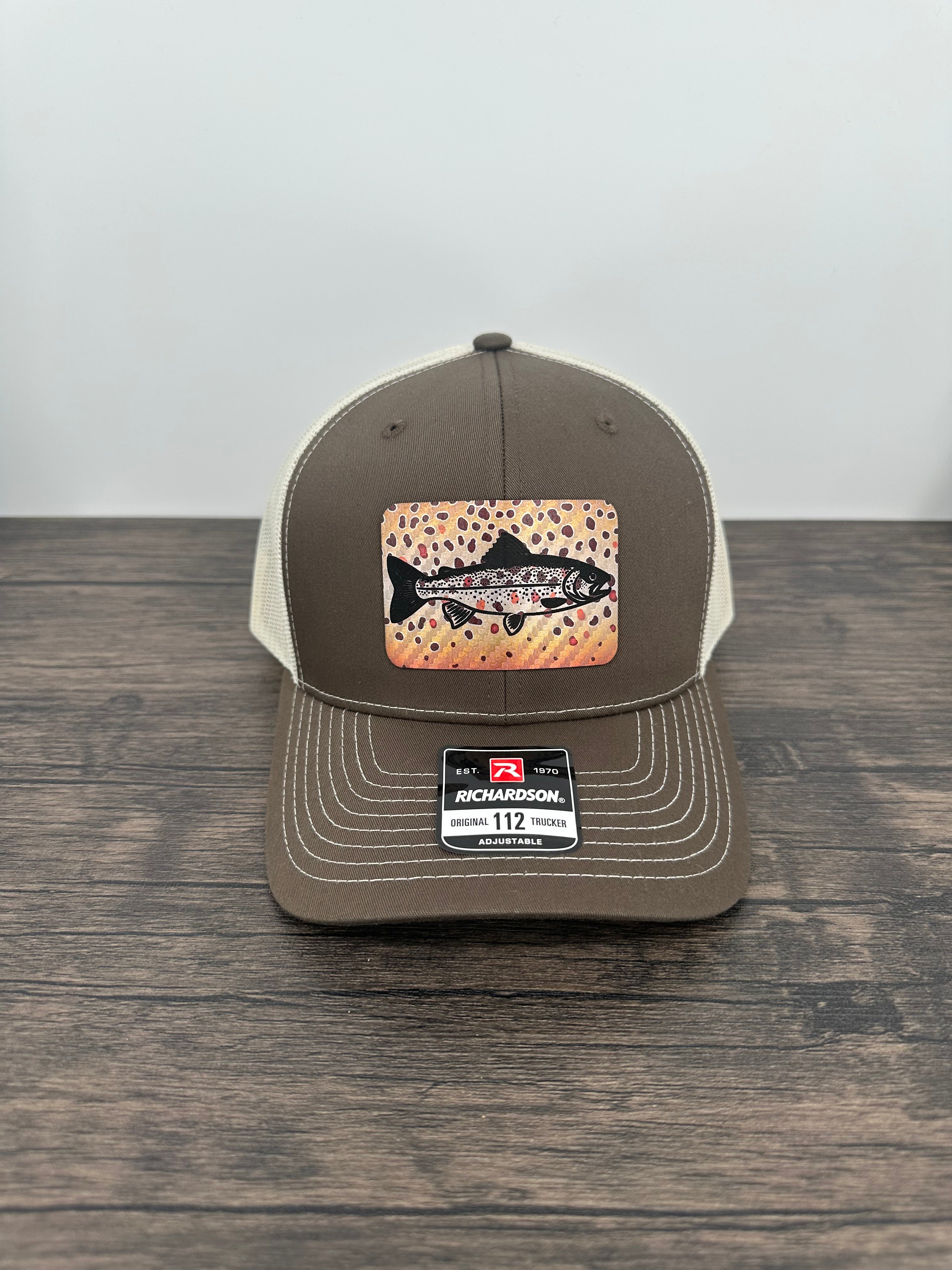 Brown and beige brown trout fly fishing hat featuring a laser engraved trout outline on a printed brown trout patch