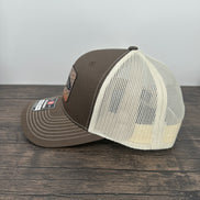 Side view of a Brown and beige brown trout fly fishing hat featuring a laser engraved trout outline on a printed brown trout patch