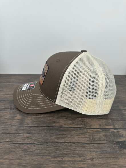 Side view of a Brown and beige brown trout fly fishing hat featuring a laser engraved trout outline on a printed brown trout patch