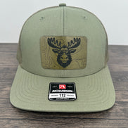 Green cap with a  moose wearing sunglasses  patch
