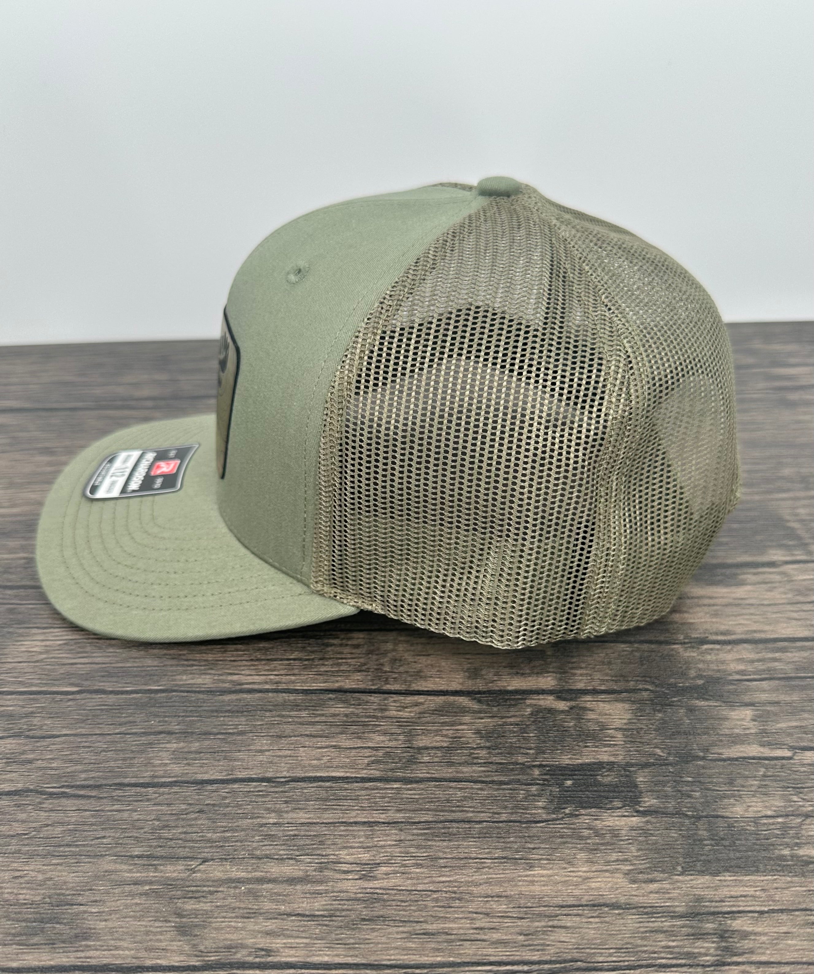 Loden green hat side view of the moose wearing sunglasses patch hat
