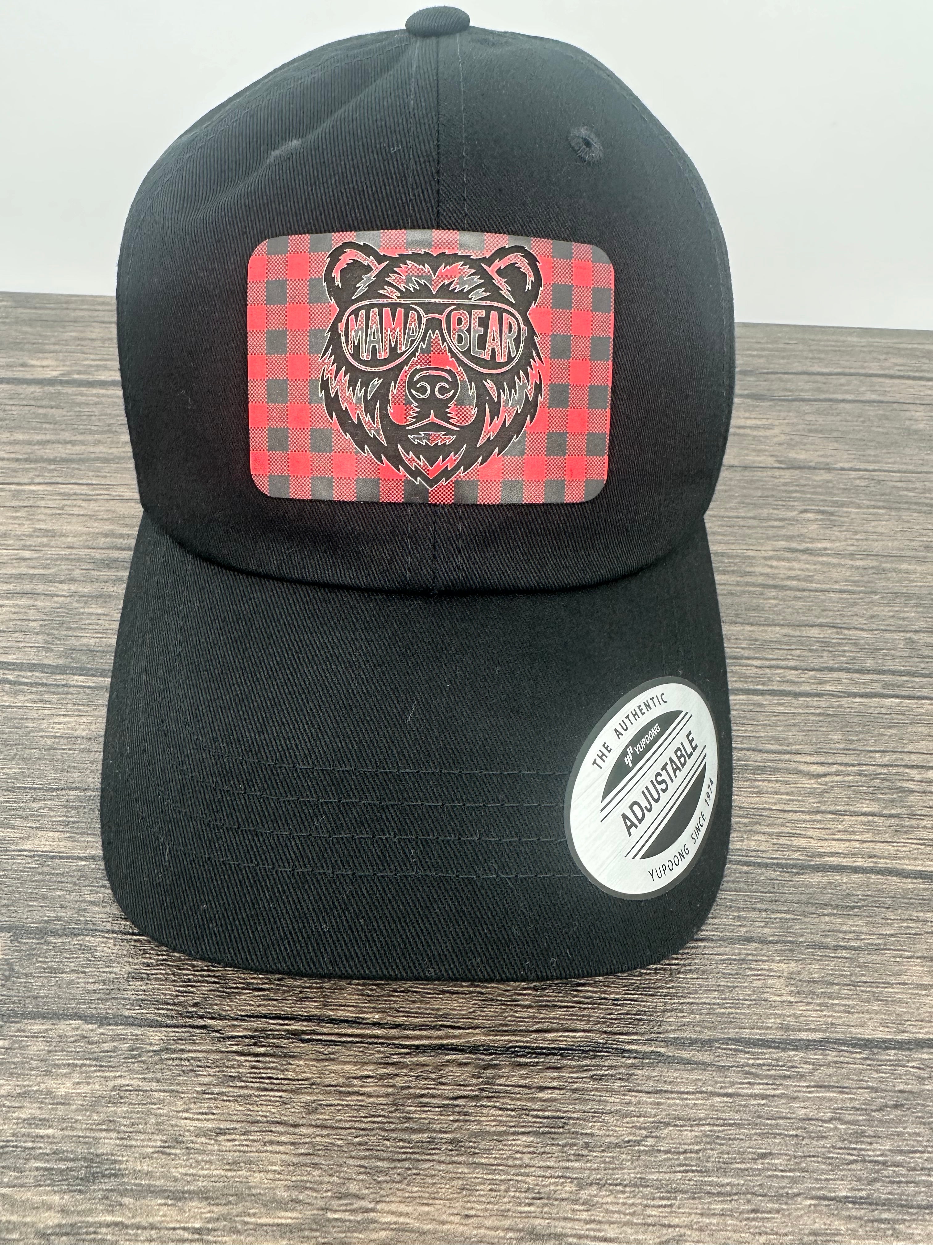 Black hat with a red and black buffalo plaid patch that has mama bear engraved on the patch