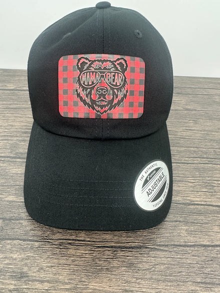 Black hat with a red and black buffalo plaid patch that has mama bear engraved on the patch