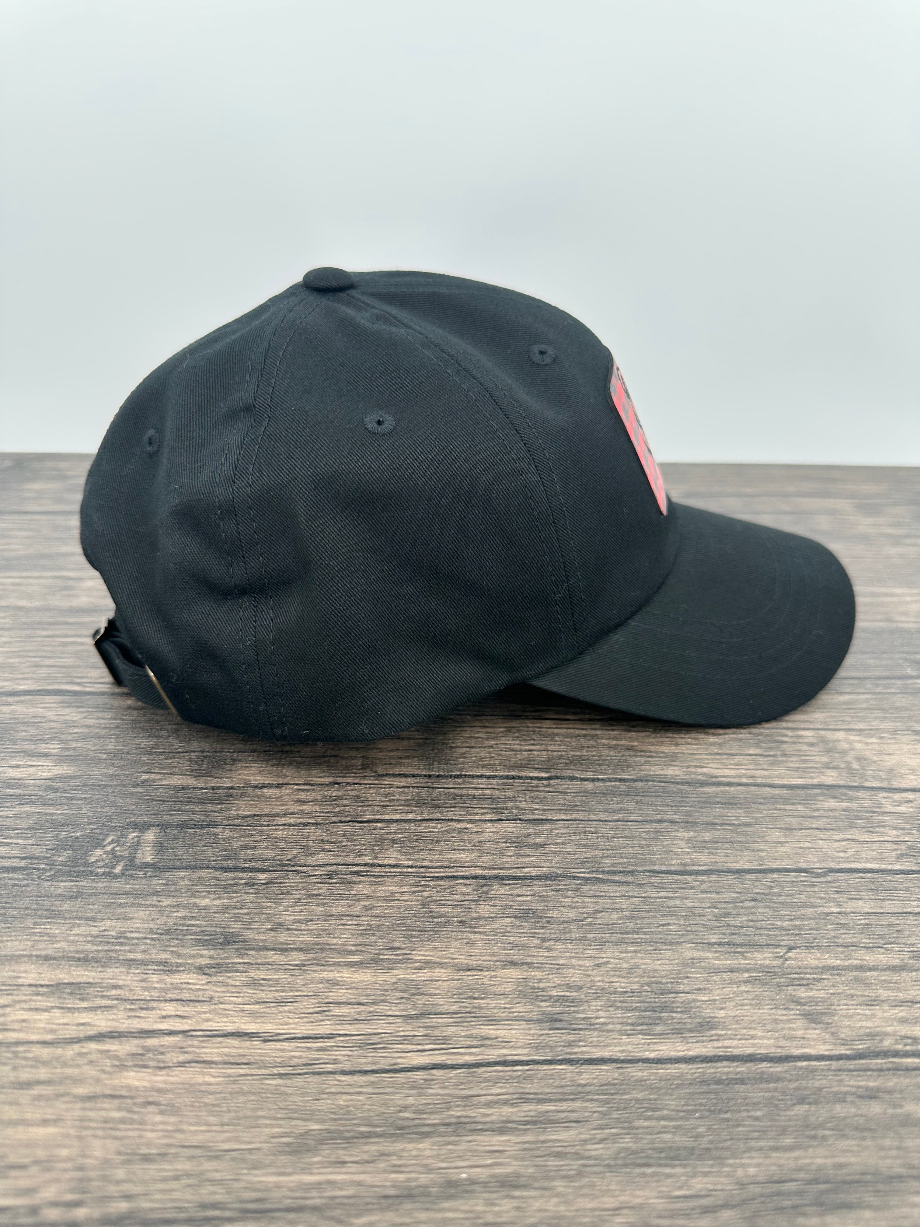 Side view of a Black hat with a red and black buffalo plaid patch that has mama bear engraved on the patch
