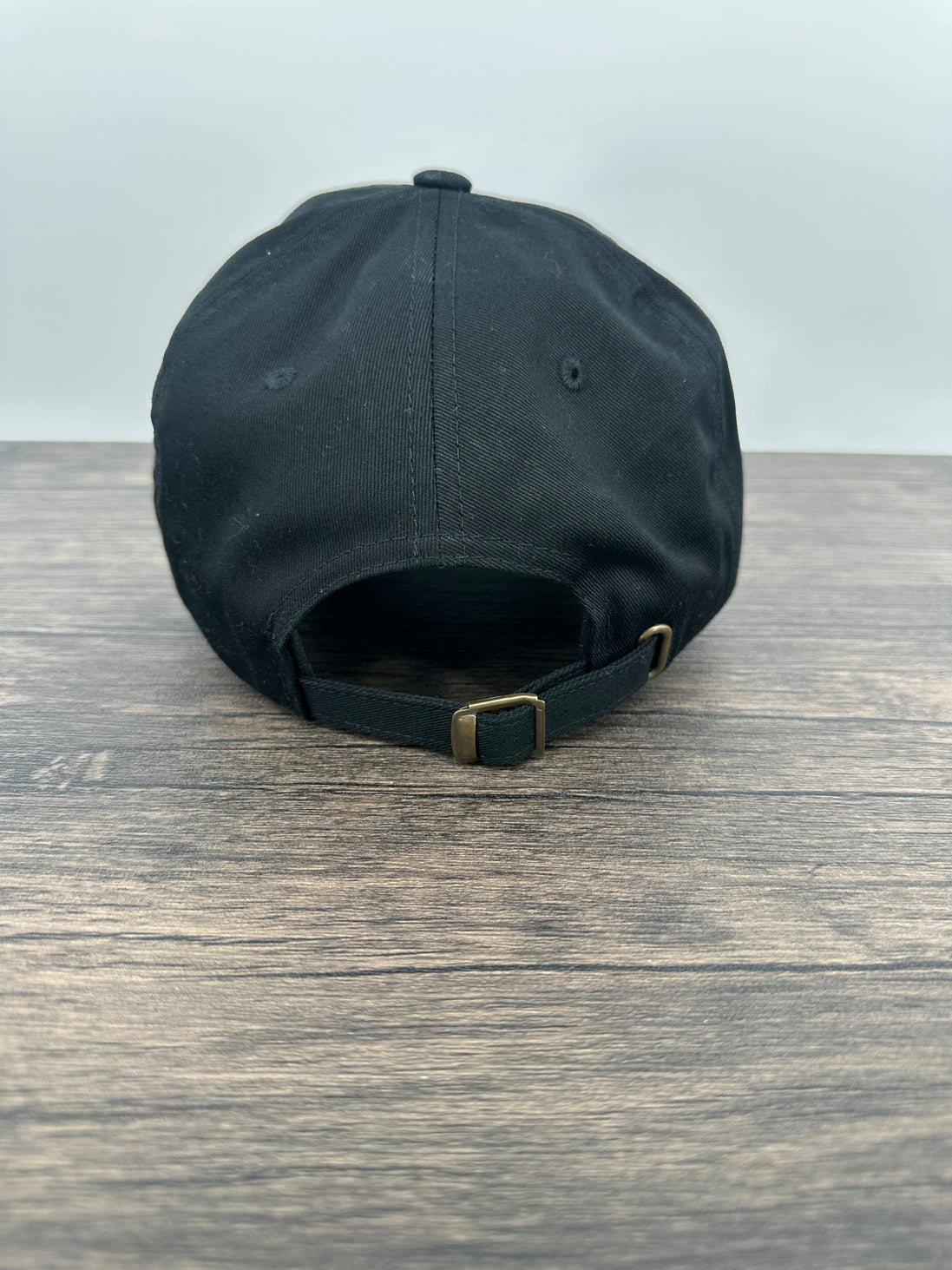 Back view of a Black hat with a red and black buffalo plaid patch that has mama bear engraved on the patch