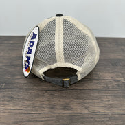 White mesh screen with black trim on a wooden surface, featuring the Adams logo.