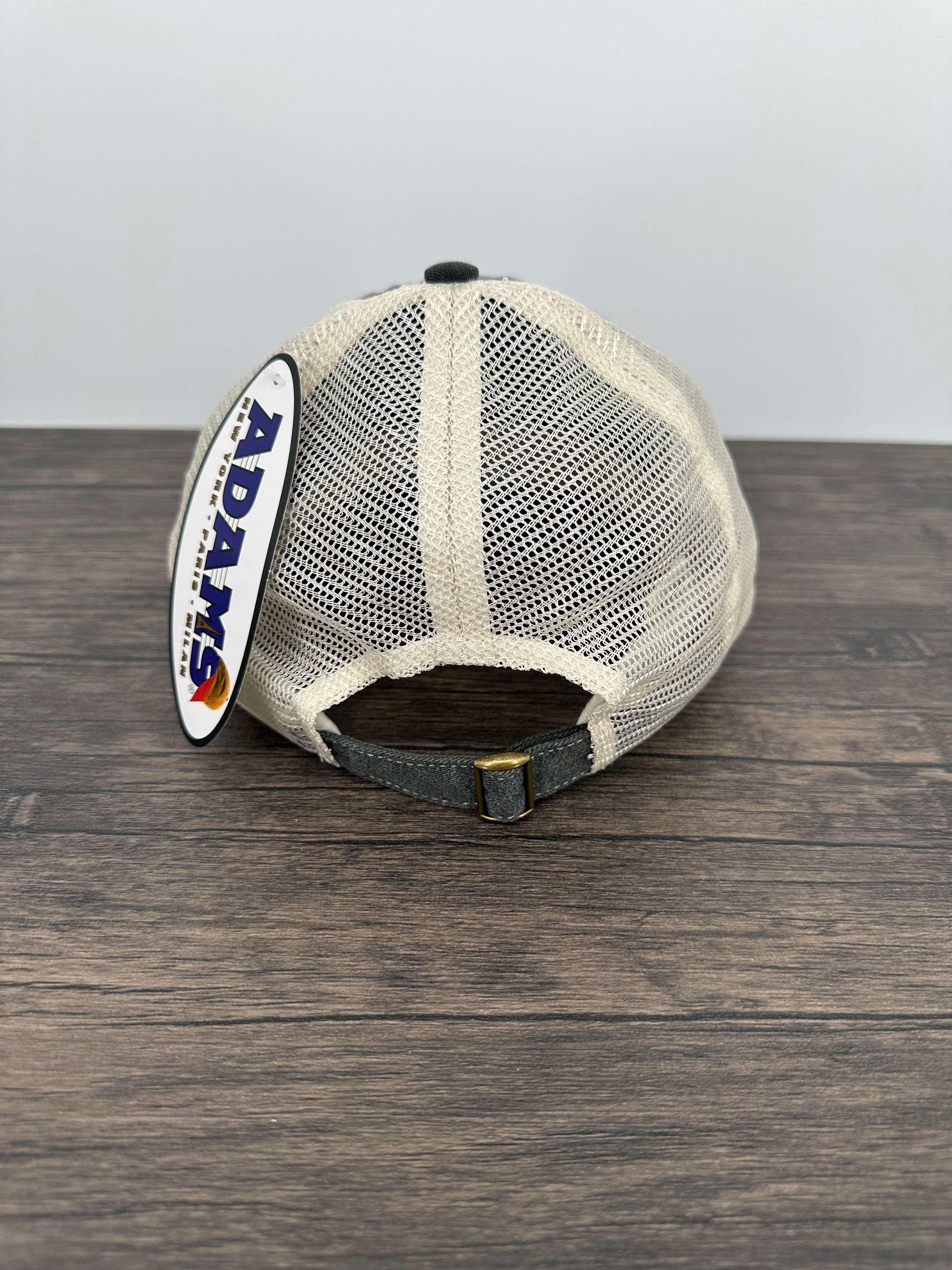 White mesh screen with black trim on a wooden surface, featuring the Adams logo.