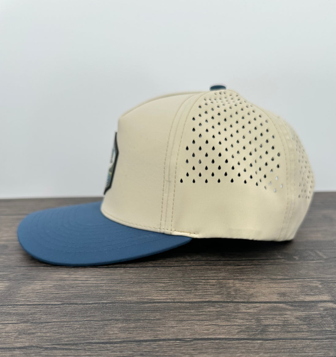 Beige and blue cap with a bass fish patch side view