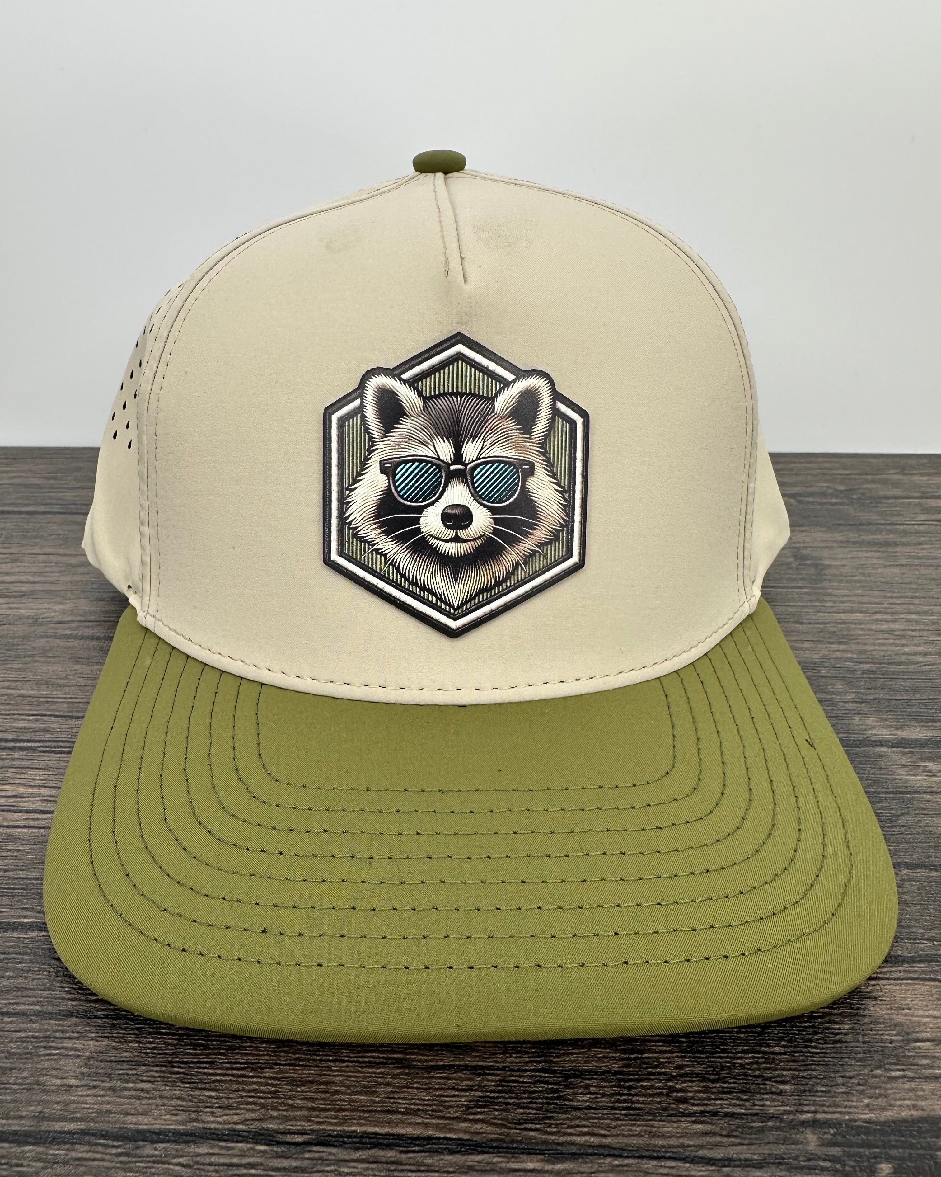 Beige and green cap with raccoon design