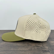Beige and green baseball cap on a wooden surface with a light gray background
