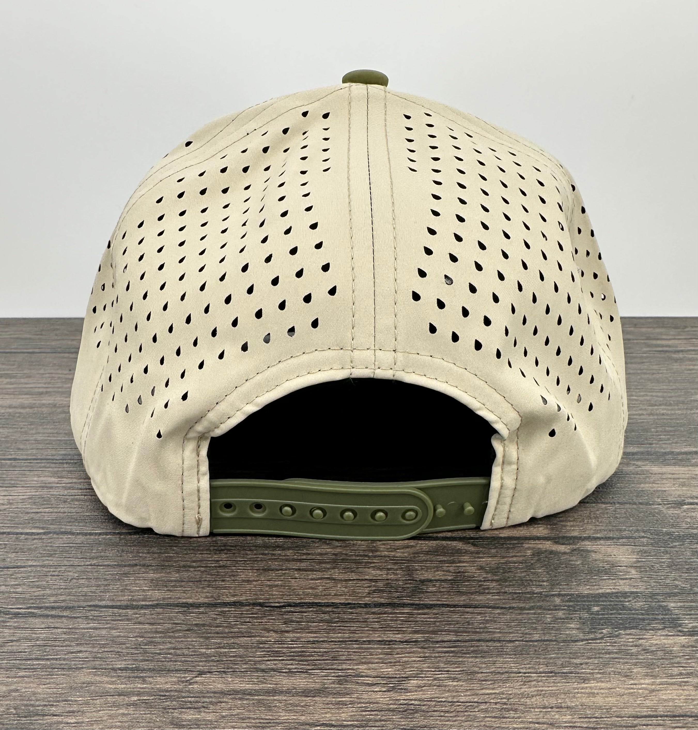 Beige cap with green brim on a wooden surface