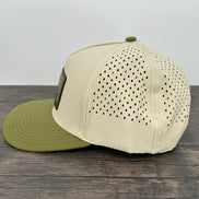 Beige cap with green brim on a wooden surface