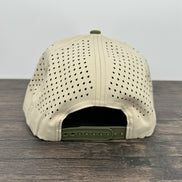 Beige cap with green brim on a wooden surface