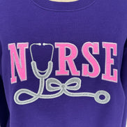 Purple shirt with 'NURSE' and stethoscope graphic in pink and silver on a white background