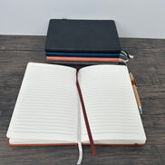 Open notebook with a pen holder on a wooden surface