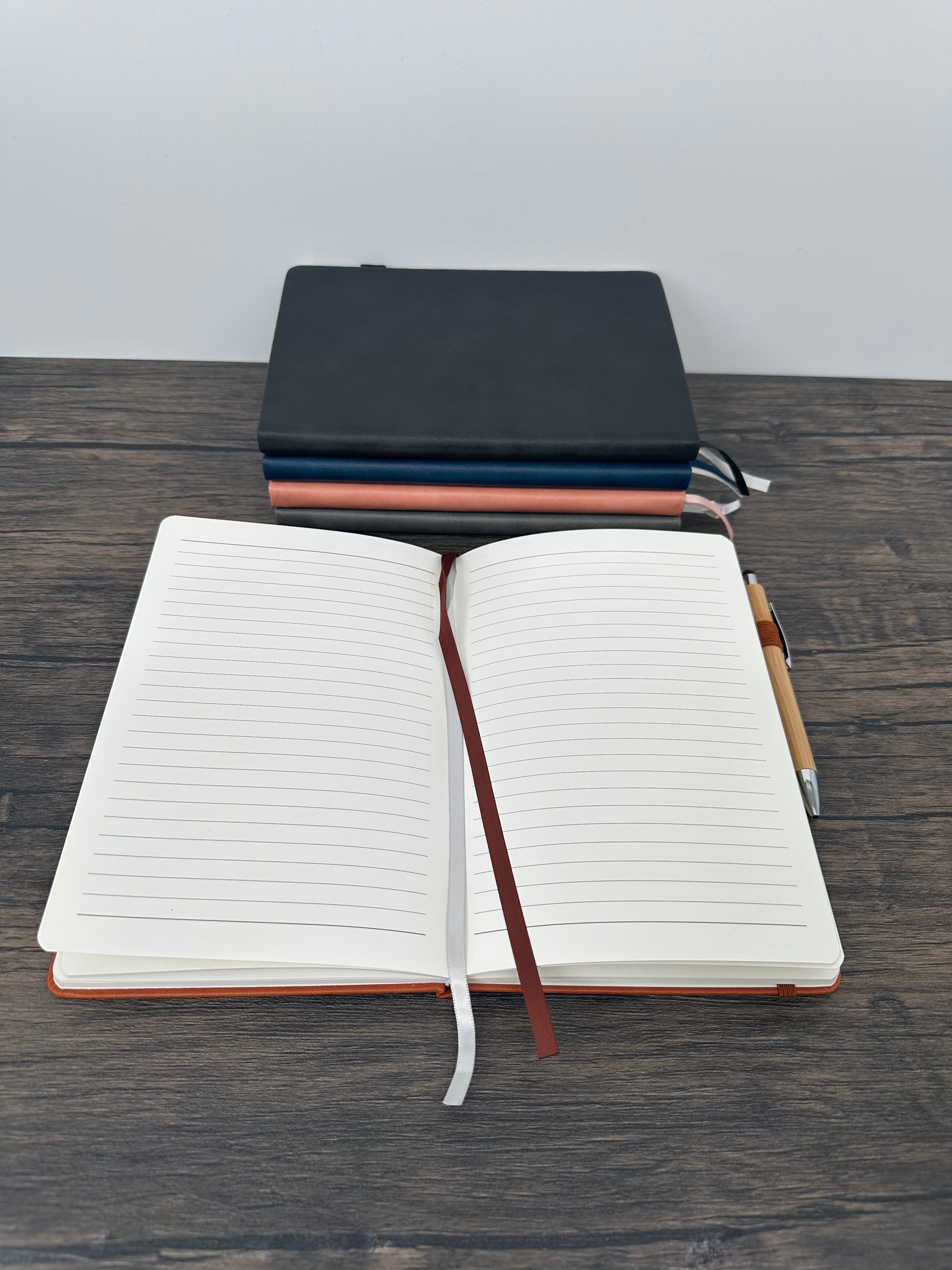 Open notebook with a pen holder on a wooden surface