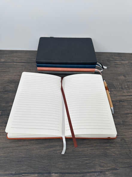Open notebook with a pen holder on a wooden surface