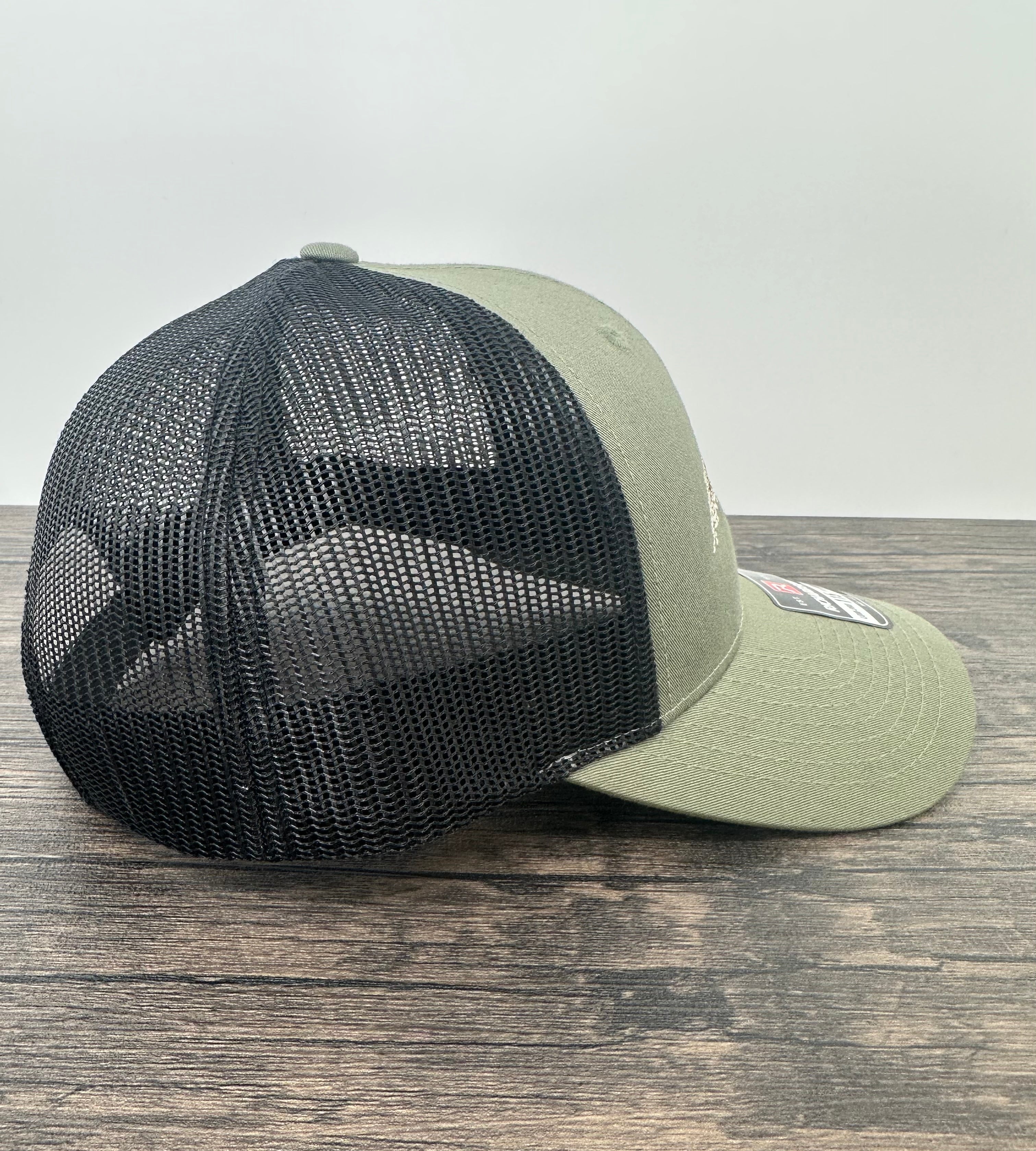 Side view of an embroidered fly fishing hat in green and black