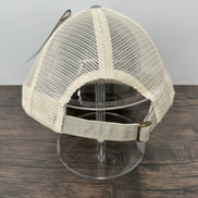 Beige mesh cap on a stand against a wooden panel background