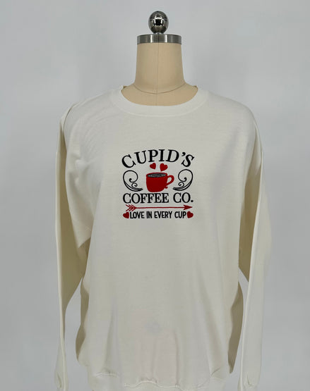 White long-sleeve shirt with 'Cupid's Coffee Co.' text on a mannequin against a white background