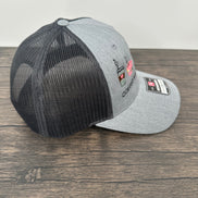 Gray and black coffee embroidered cap with mesh back on a wooden surface