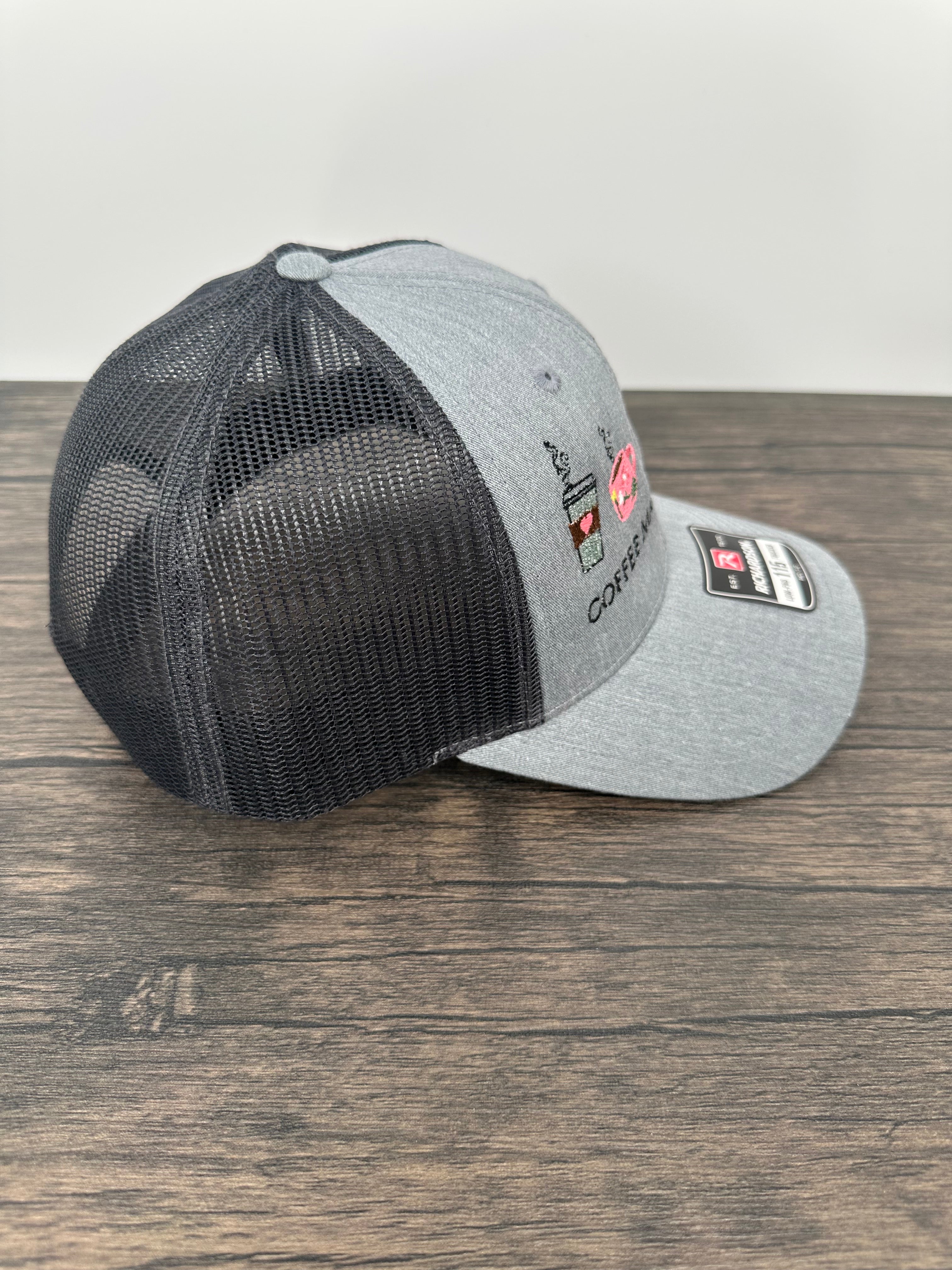 Gray and black coffee embroidered cap with mesh back on a wooden surface