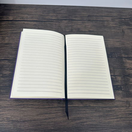 Open notebook with lined pages on a wooden surface