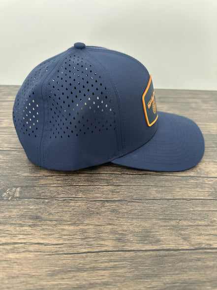 Side view of a fly fishing patch hat with a silicone patch with a fly fishing rod and reel