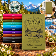 A personalized prayer journal shown in an outdoor mountain-and-lake setting, with a stack of other journal color options on the left and a circular inset showing the journal's dimensions. The main journal is olive green with black printed artwork and text, and the cover is personalized with the name Stacie.