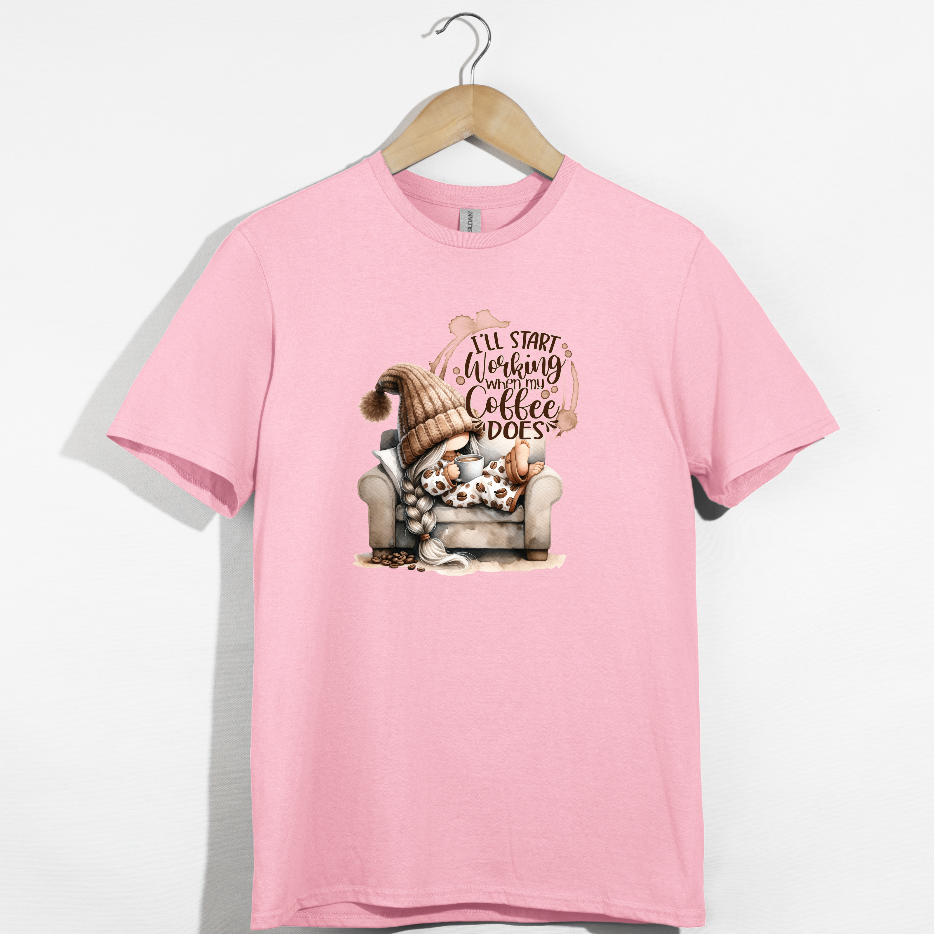 Pink t-shirt with a graphic of a gnome and text that says i’ll start working when my coffee does
