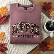 Coffee Weather sweatshirt folded with cozy background