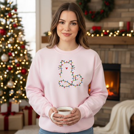 Model wearing light pink sweatshirt in Christmas setting